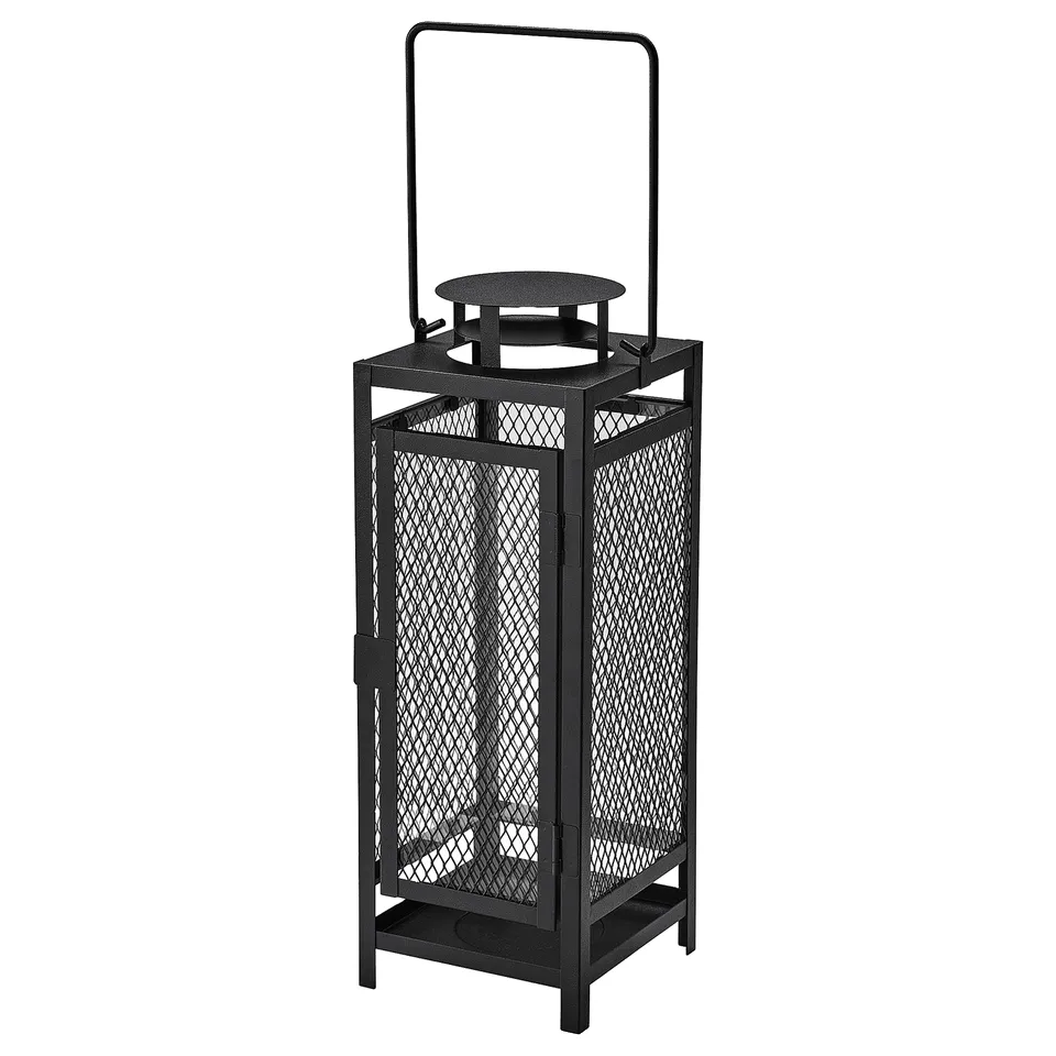 Black metal lantern with handle, suitable for indoor/outdoor use, emits warm candlelight through cutout patterns.