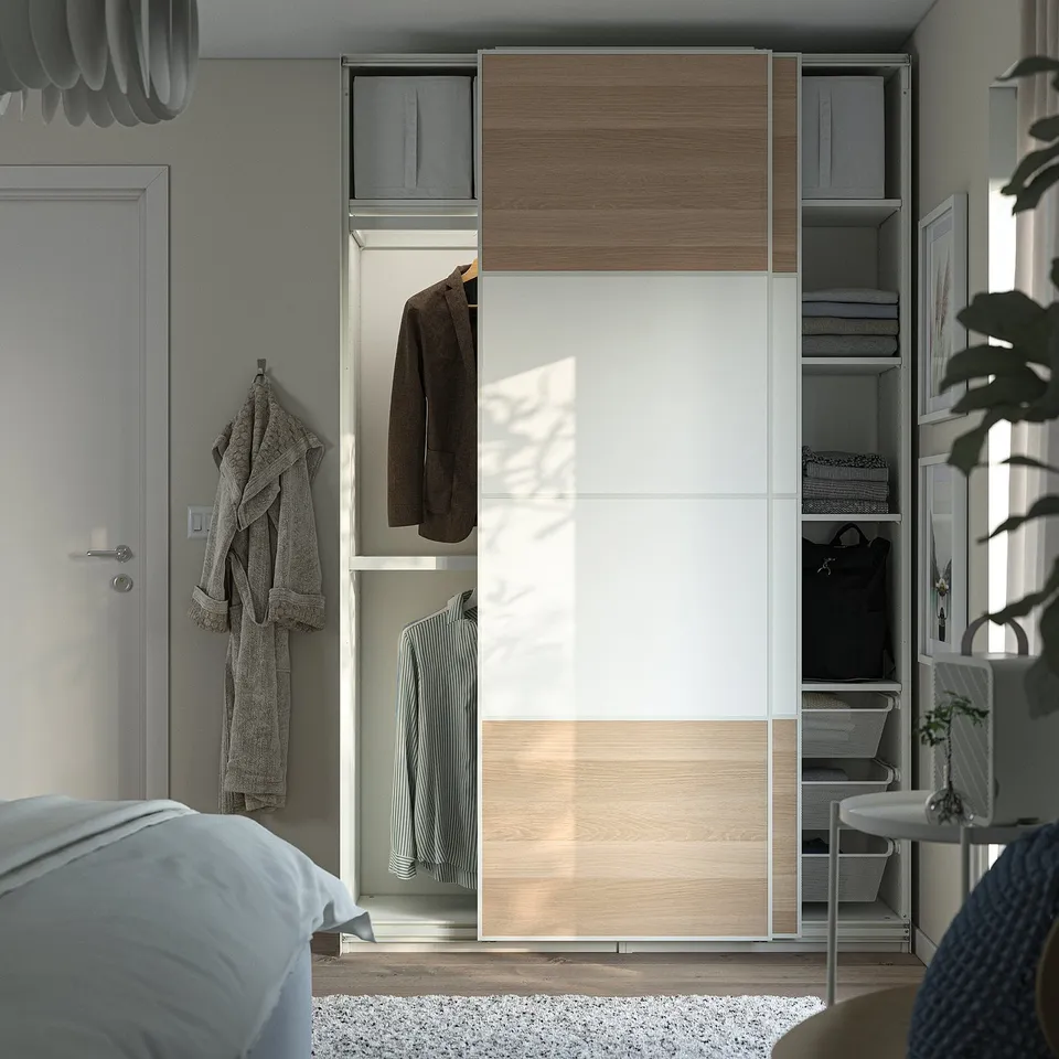 Modern wardrobe with sliding mirrored doors and interior hanging and shelving storage.