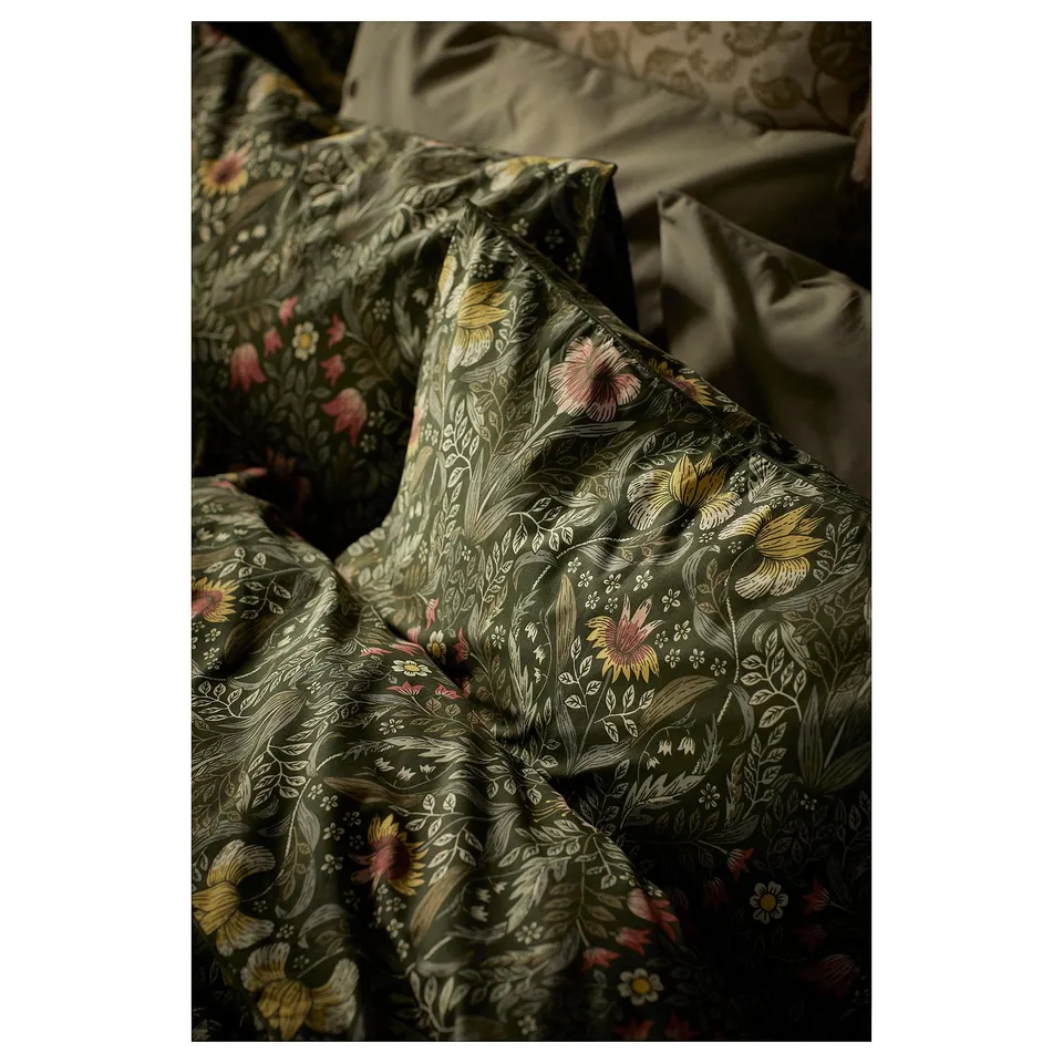 Floral patterned dark green duvet set featuring intricate nature-inspired design, neatly folded with a matching pillow.