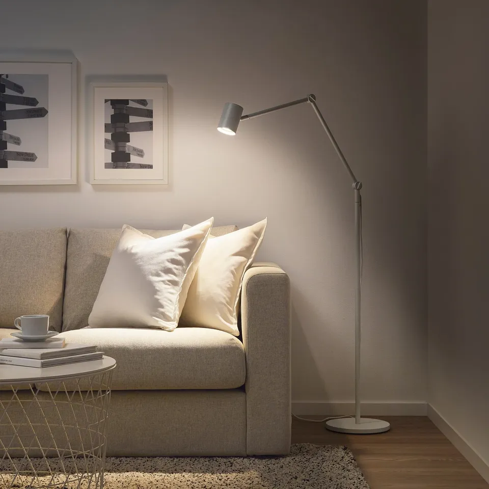 Modern living room with beige sofa, floor lamp, and art.