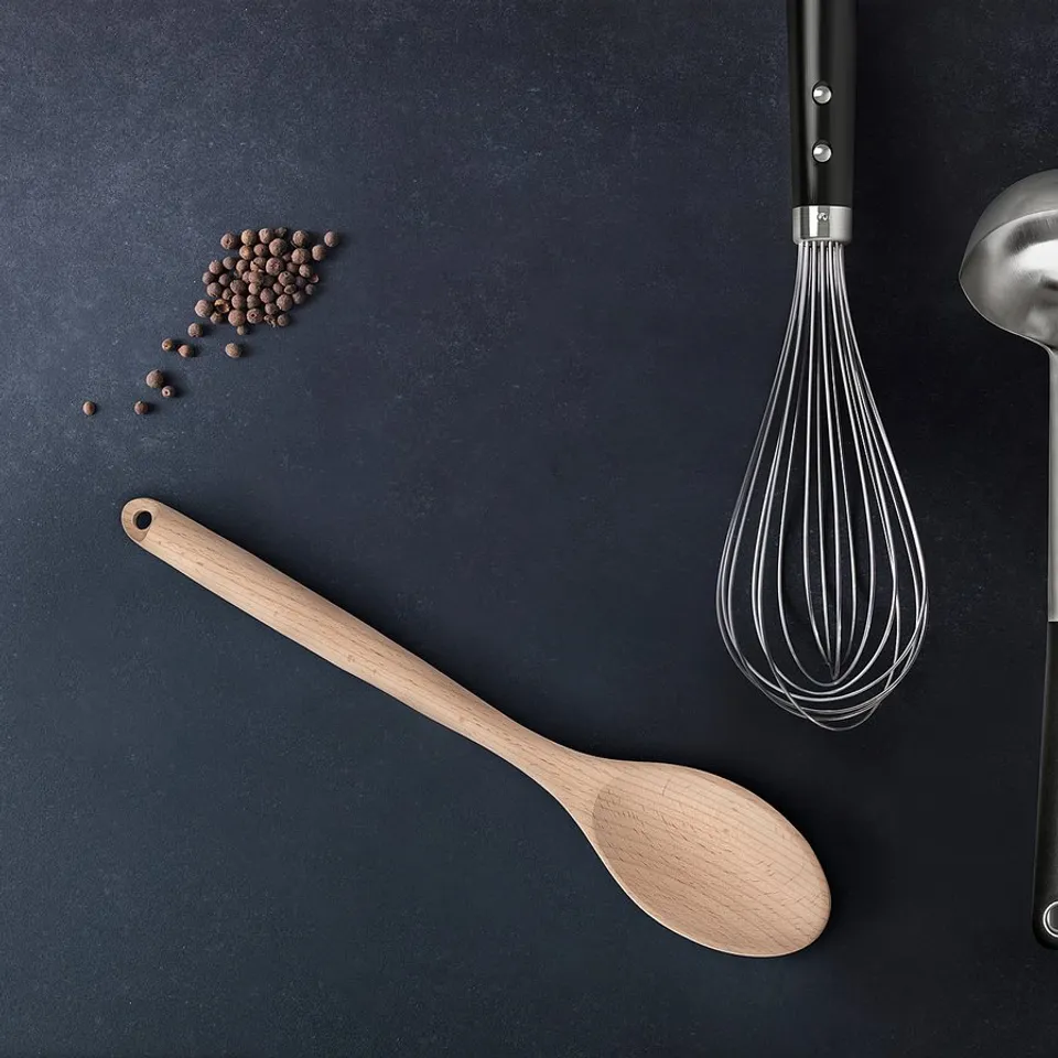 RÖRT kitchen utensils: black handle, wood & metal. Includes spatula, whisk, ladle, and spoon. Arranged on dark background with peppercorns.