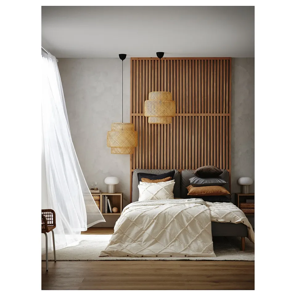 Minimalist bedroom with wooden slats, sheer white curtains, and wicker pendant lights.