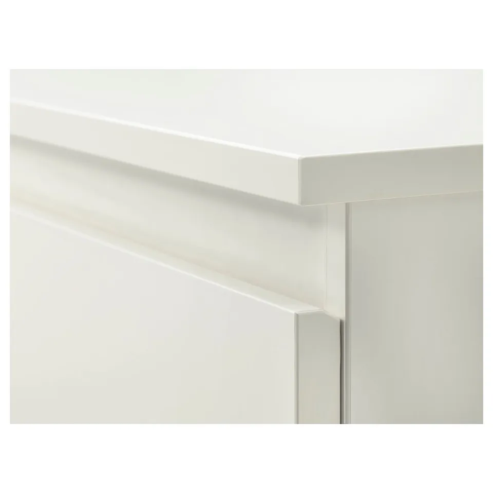 Clean, white chest of drawers close-up. Smooth edges and sleek design. Modern minimalist style.
