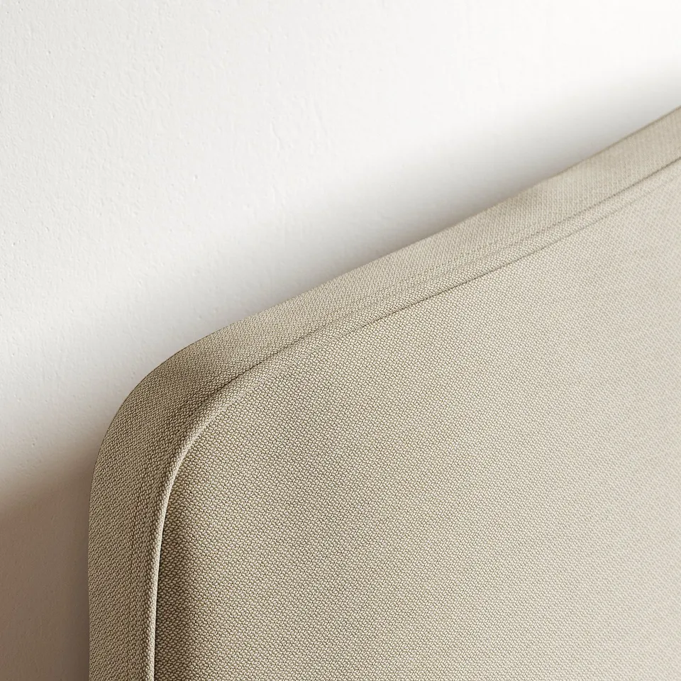Close-up of a beige upholstered headboard showcasing its smooth fabric and clean stitching.