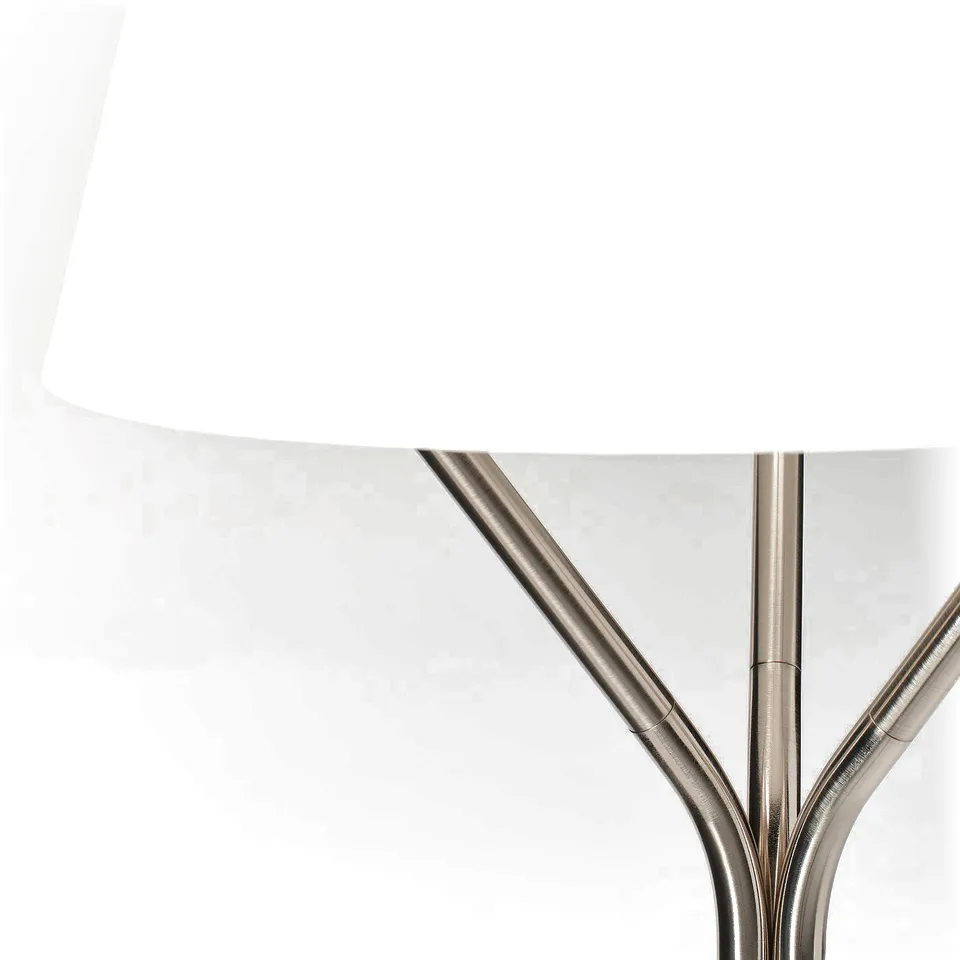 Sleek modern lamp with polished metallic tripod base and white shade, offering stylish lighting.