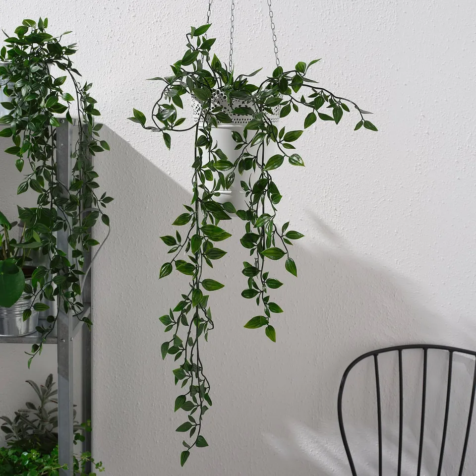 Several artificial green plants in hanging pots, creating an indoor garden.