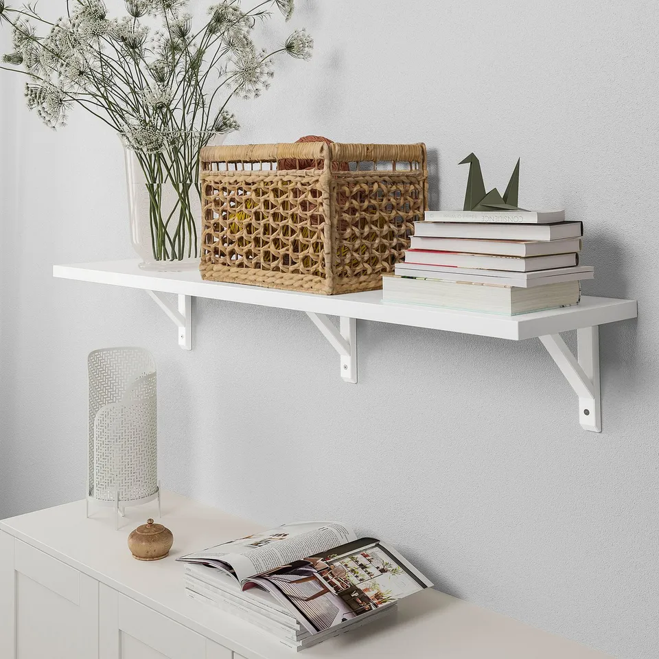 Wall-mounted shelf holds books, basket, vase, magazines. Or, for a more concise version: shelf with books, basket, vase, magazines.
