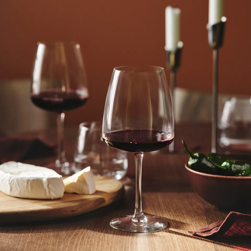 Wine glasses and cheese on wooden table. Glasses for bold red wine.