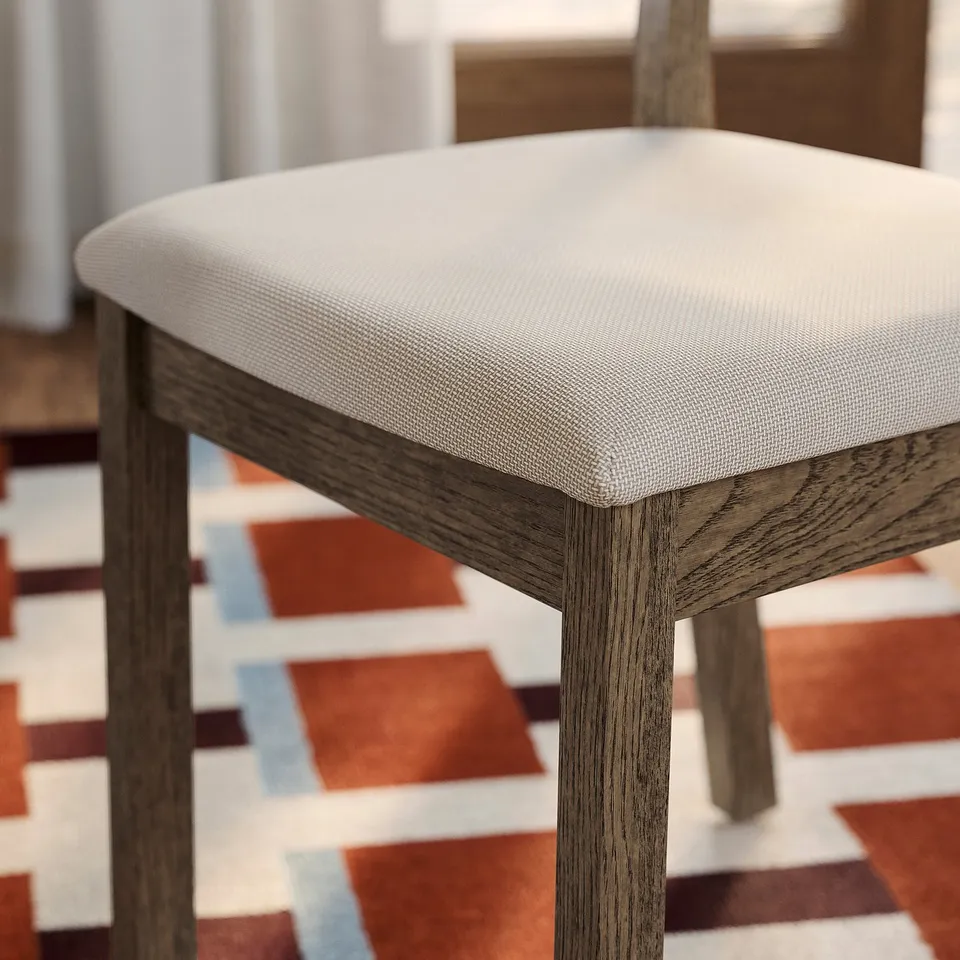 Stool with plush, white fabric seat on sturdy, wooden legs.