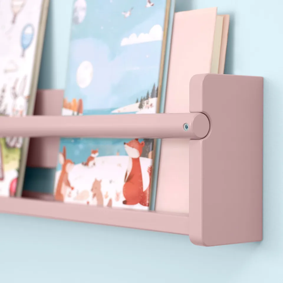Wooden bookshelf in light pink, mounted on a light blue wall. Holds picture books and small toys. Adjustable, sturdy, child-friendly design.