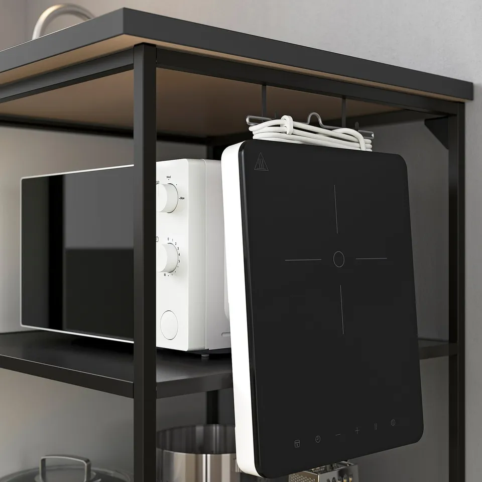 Black ENHET kitchen shelf storing a white microwave and a black tablet. Displaying kitchen items neatly.