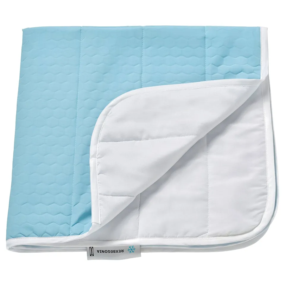 Light blue cooling pad, rectangular, quilted texture with white piping, branded REXBEGONIA.