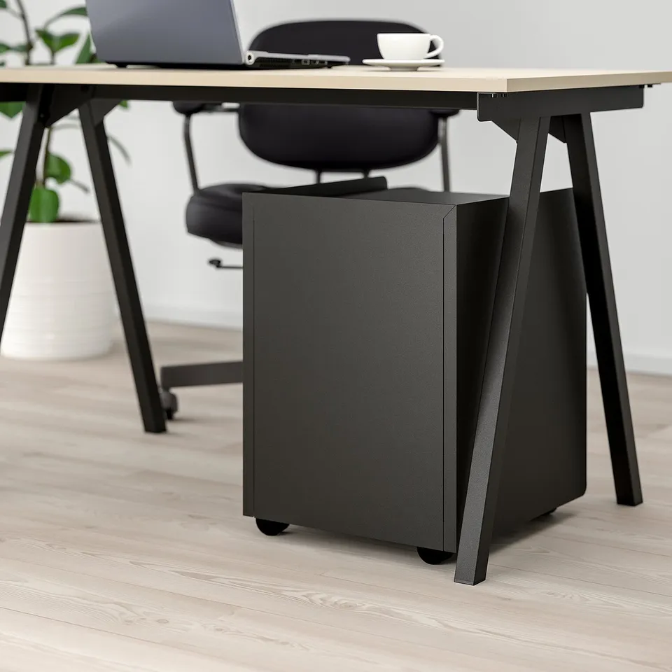 Black office storage unit with wheels under desk, lockable for private items.
