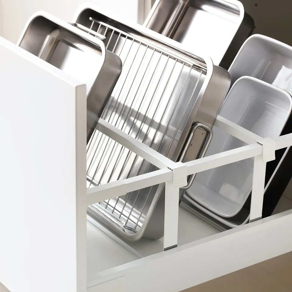 Kitchen drawer organiser storing metal baking trays, showing adjustable shelves.