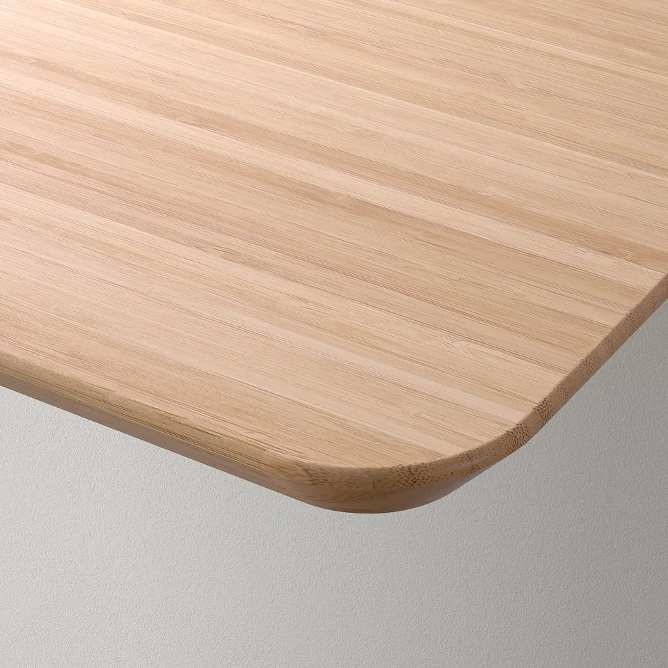 Close-up of a smooth, light wooden tabletop with a gently rounded edge, showcasing its natural grain and finish.