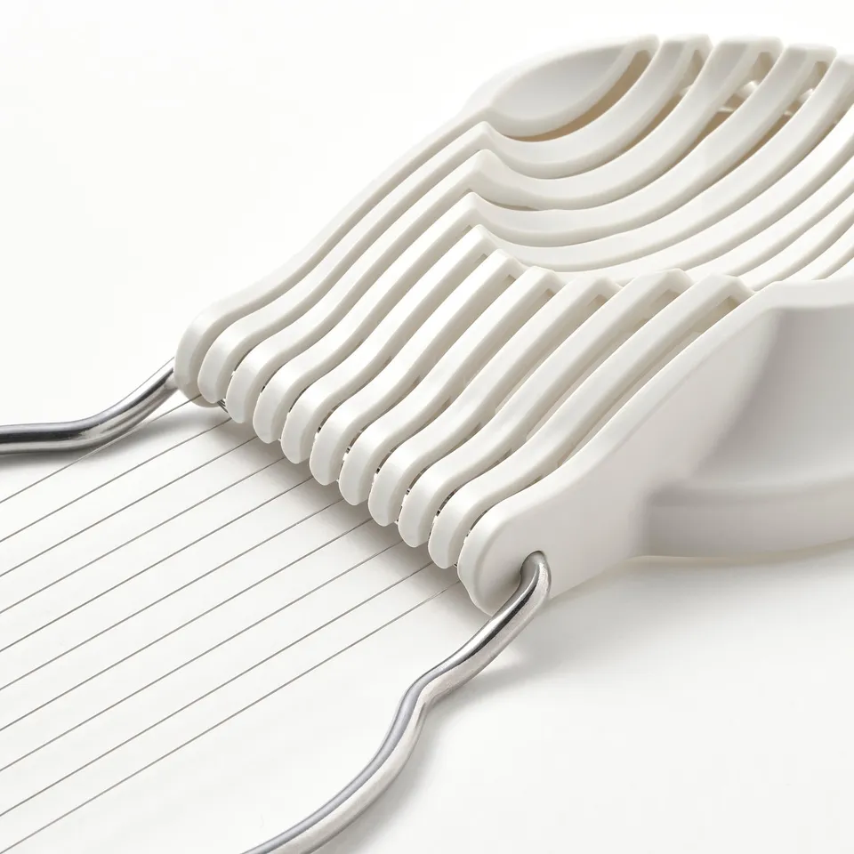 Parsing and slicing kitchen tool, shown in white, with metallic handles, neatly arranged.