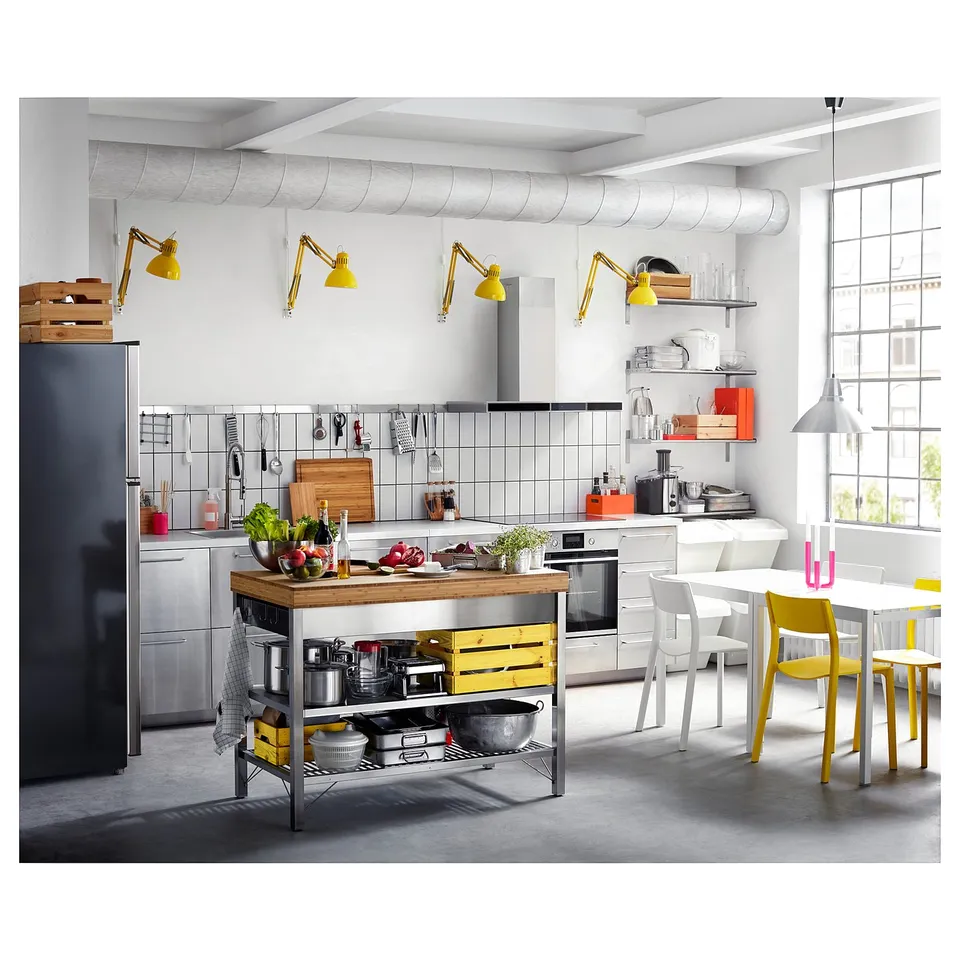 Modern kitchen with white cabinets, stainless appliances, bamboo island, hanging lamps.