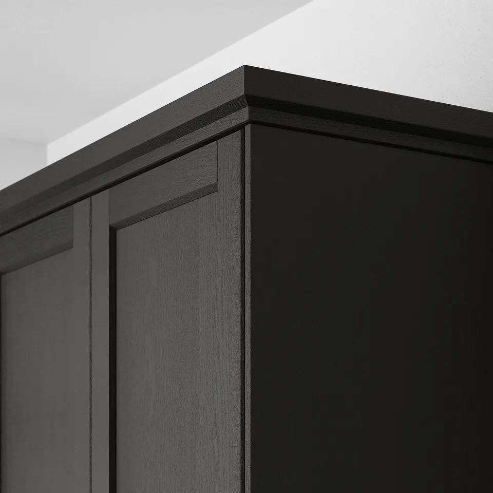 Black wooden cabinet corner with bevelled edges.