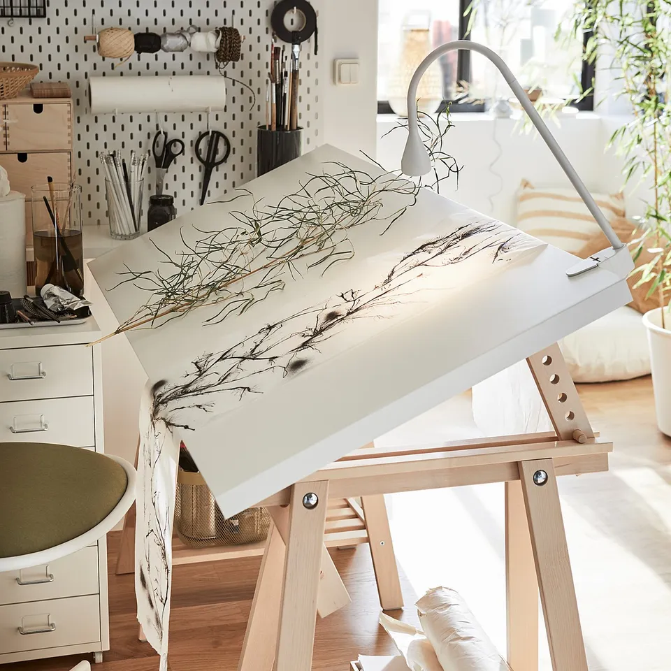 Art studio with MITTBACK white desk, wooden legs, tilted table, drawing, art supplies.