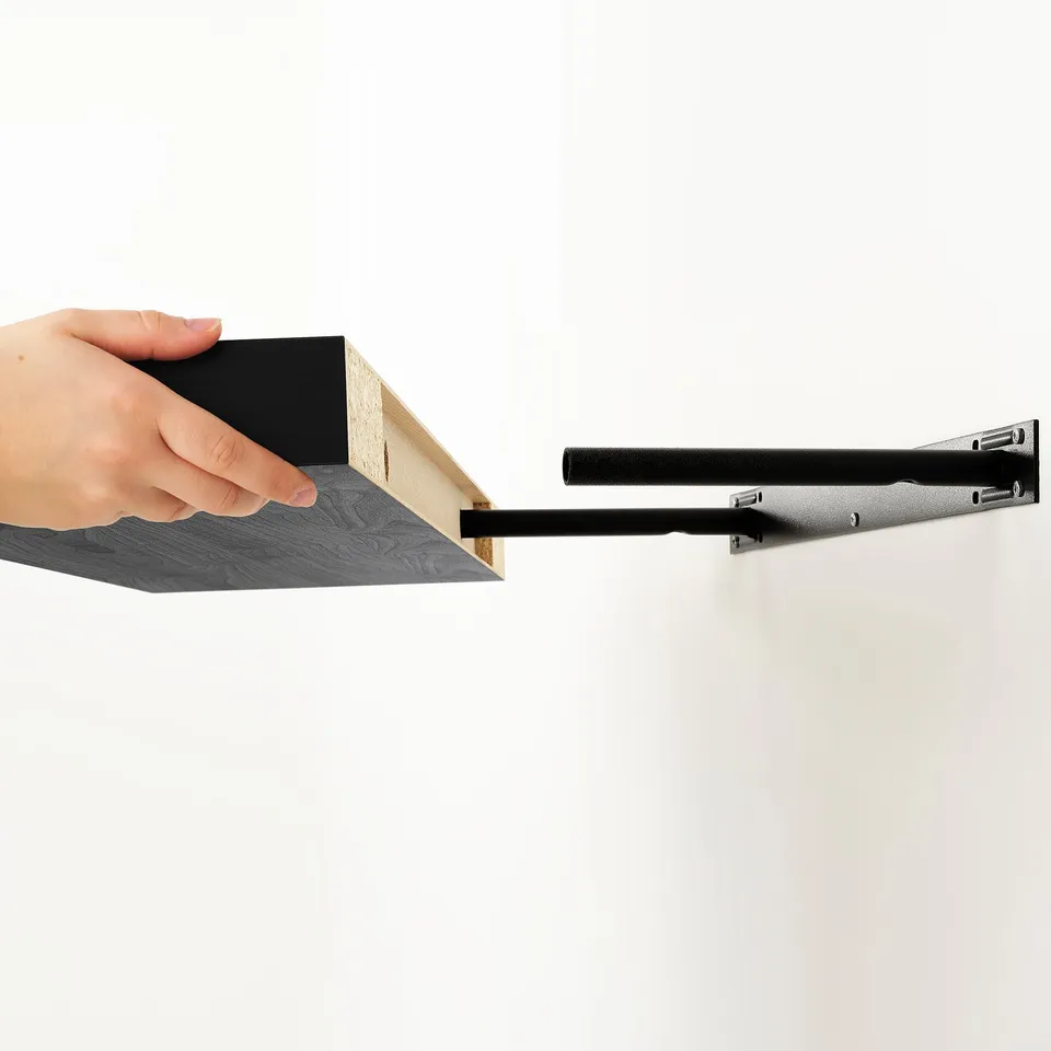 Hand placing black shelf on wall bracket.