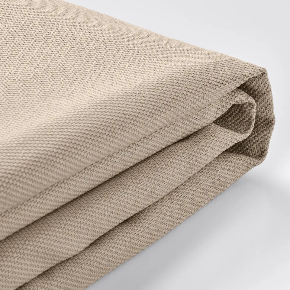 Folded beige fabric, slightly textured, likely sofa cover, high quality cotton blend.