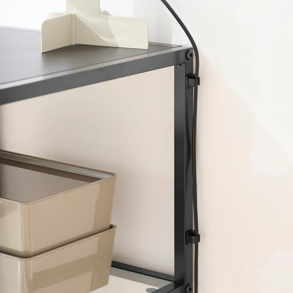 Desk with glass top, beige bins, and cord management clips.