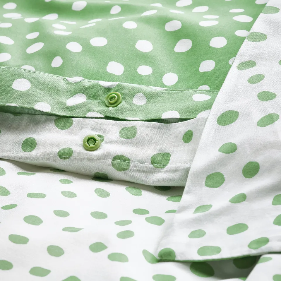 Green polka dot duvet set, featuring snap closures for easy use, displayed on a flat surface.