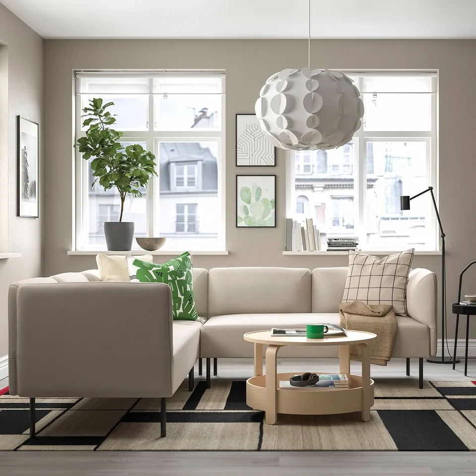 Modern living room with large grey LILLEHEM modular sofa, green pillows, wooden coffee table, and large windows.