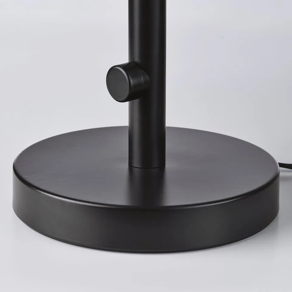 Black metal lamp base with frosted glass, robust design.