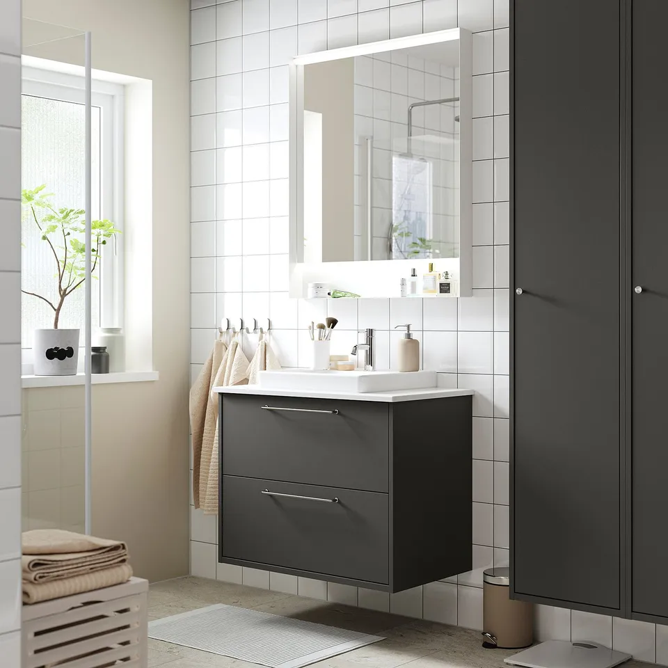 Modern dark grey bathroom vanity, wall-mounted. White countertop, large mirror, clean design.