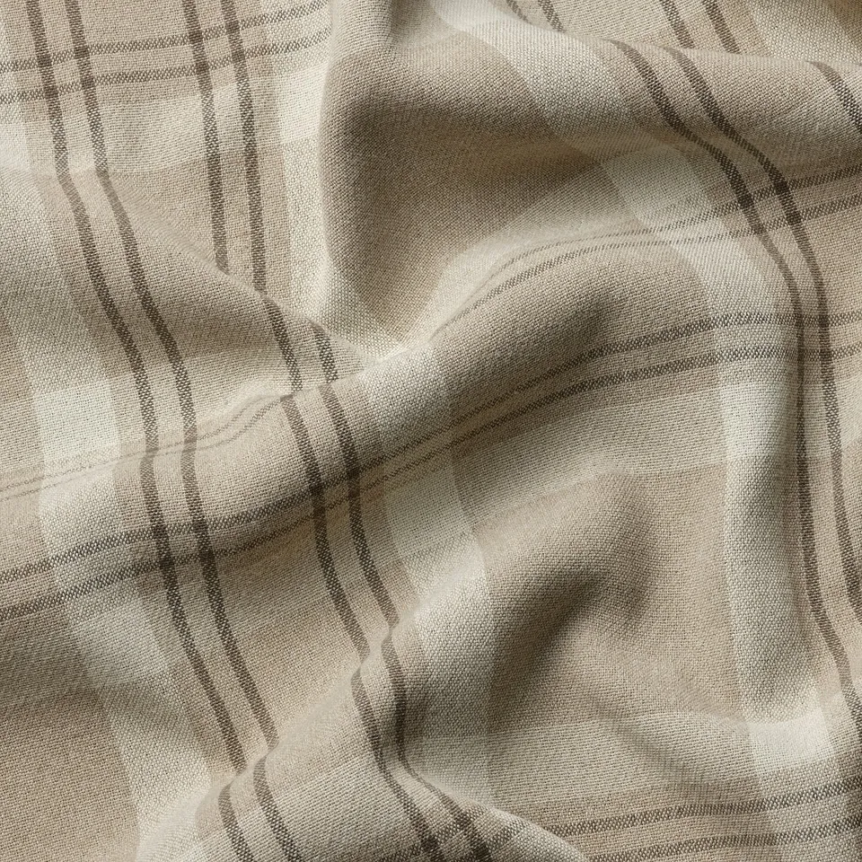 Beige tartan curtains, neatly draped. Classic pattern, quality texture.