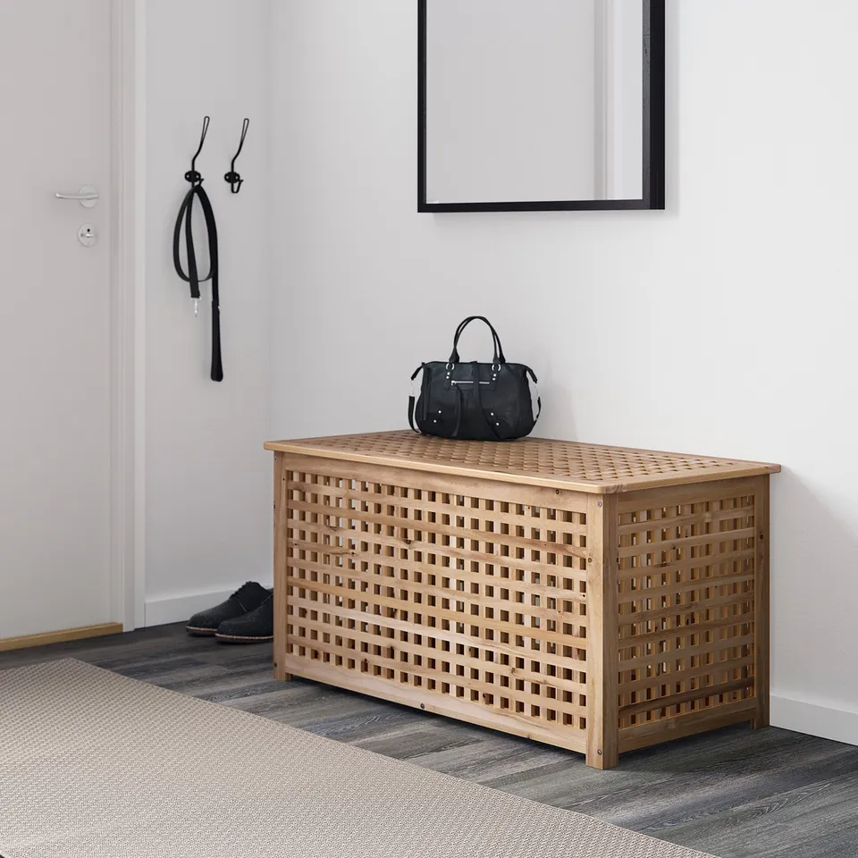 Handbag on wooden lattice storage bench by entrance, reflecting simplicity and functionality.