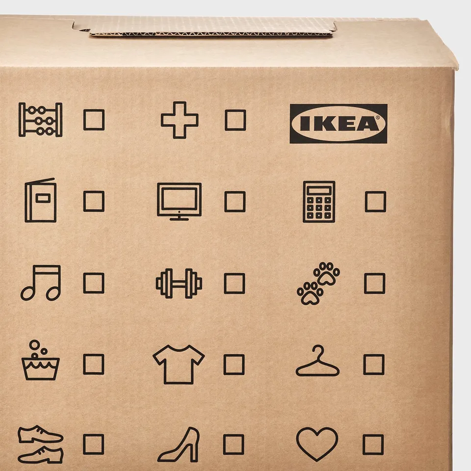 Ikea cardboard moving box with various symbols for content labeling, folded handles for easy carrying.