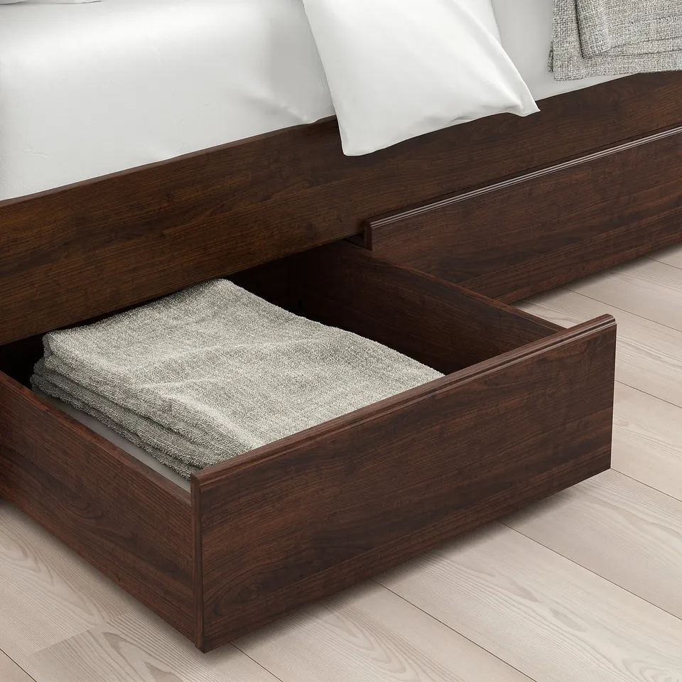 Wooden bed with open storage drawer under cool mattress.