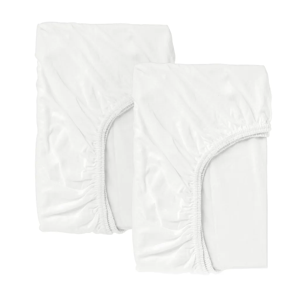 Two crisp white fitted crib sheets, made of cotton, displayed neatly.
