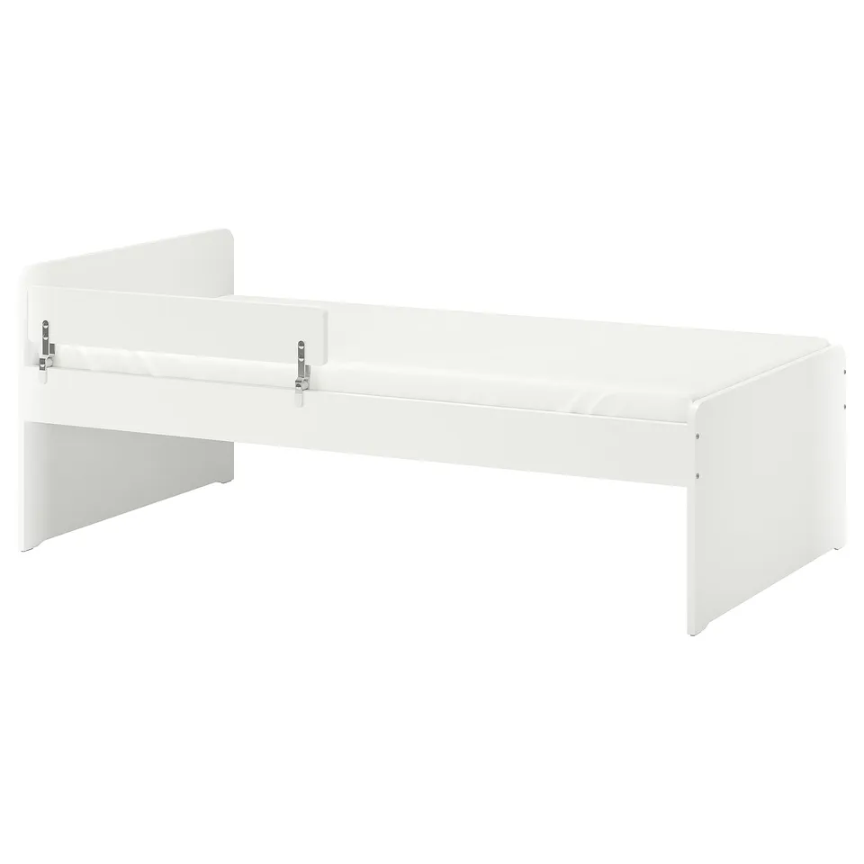White SLÄKT kids bed with rounded corners and included guardrail, made of particleboard and acrylic paint.