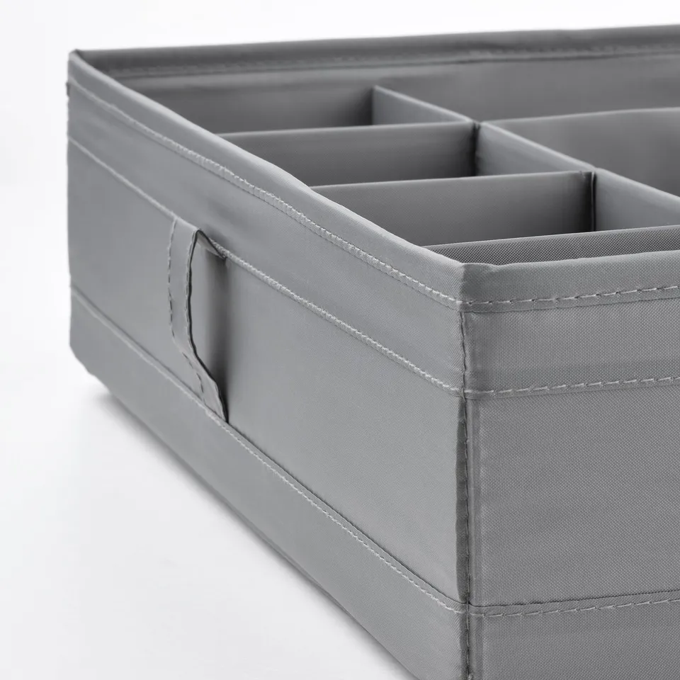 Grey fabric organiser with multiple compartments, sturdy stitching, and a handle on the side.