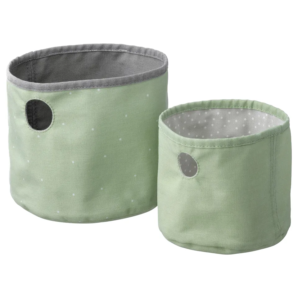 Two pale green storage baskets with white polka dots, round shape, handles, and reversible design.