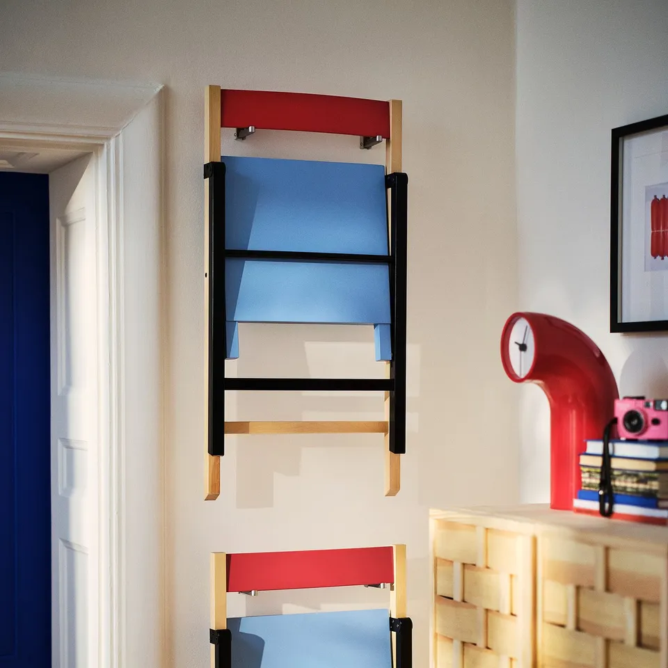 Colourful hanging wall chair with blue seat and red backs, showcasing a playful and durable design.