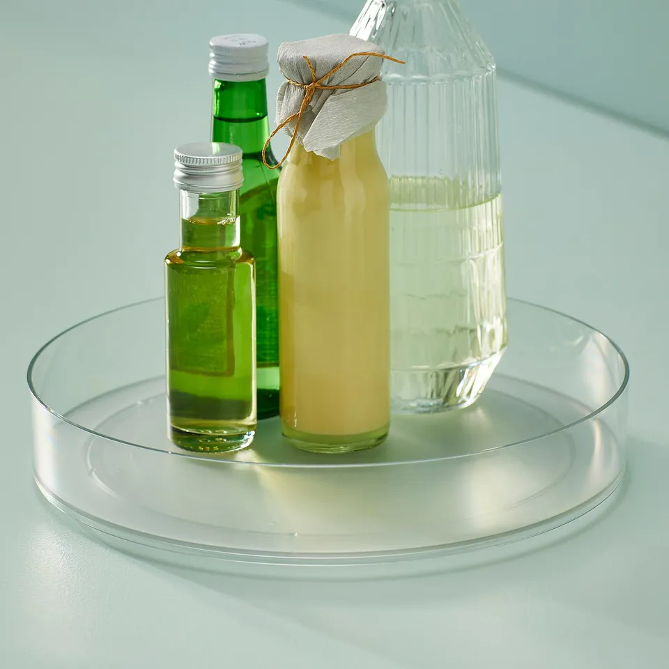 Glass turntable with green, yellow, and clear bottles.
