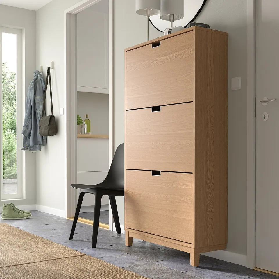 Light brown STÄLL shoe cabinet in hall, 3 compartments, chair & door.
