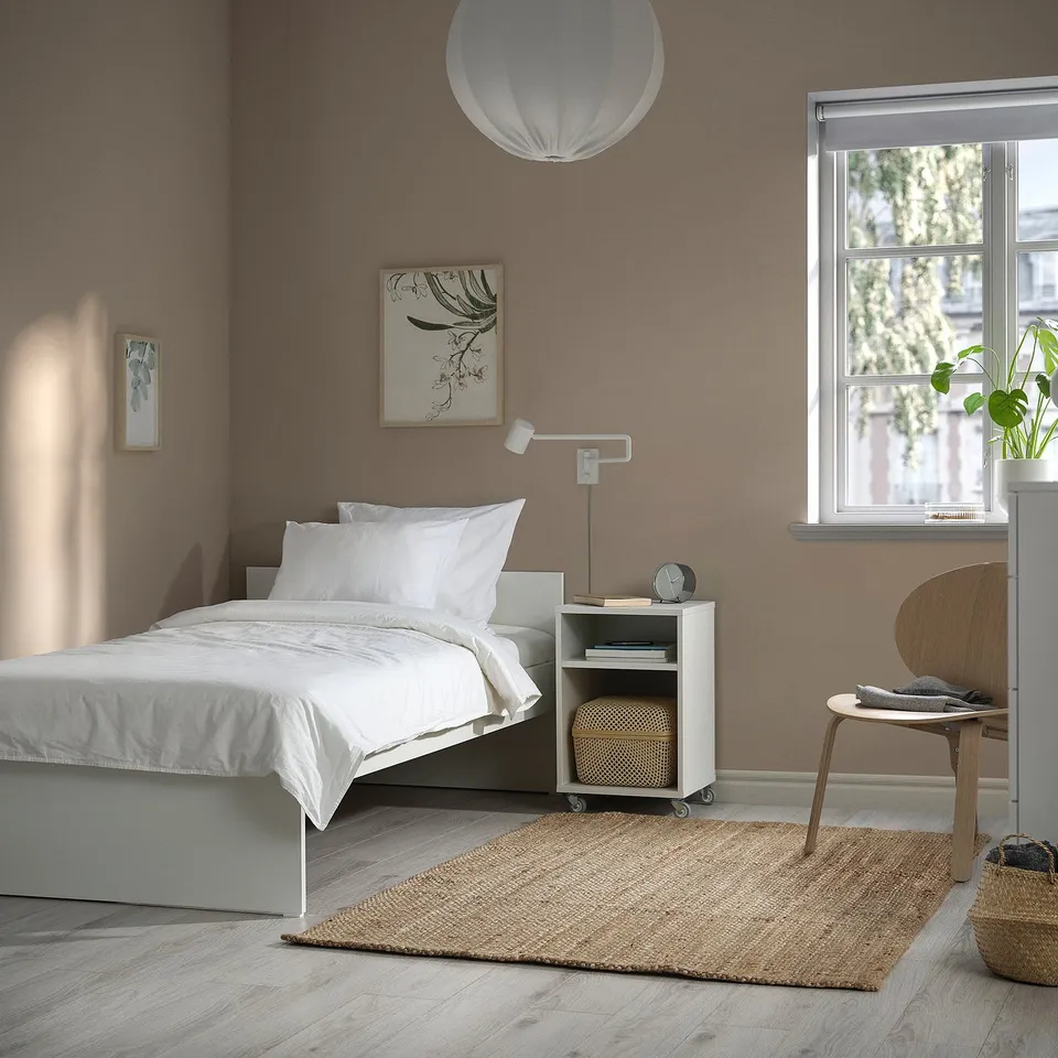 Minimalist bedroom with VIHALS bed, jute rug, and wooden bedside table.