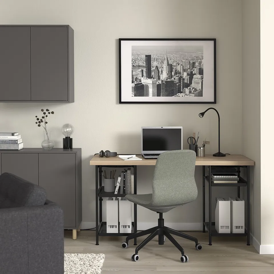 Minimalist home office with SPÄND desk, green chair, computer, and cityscape print.