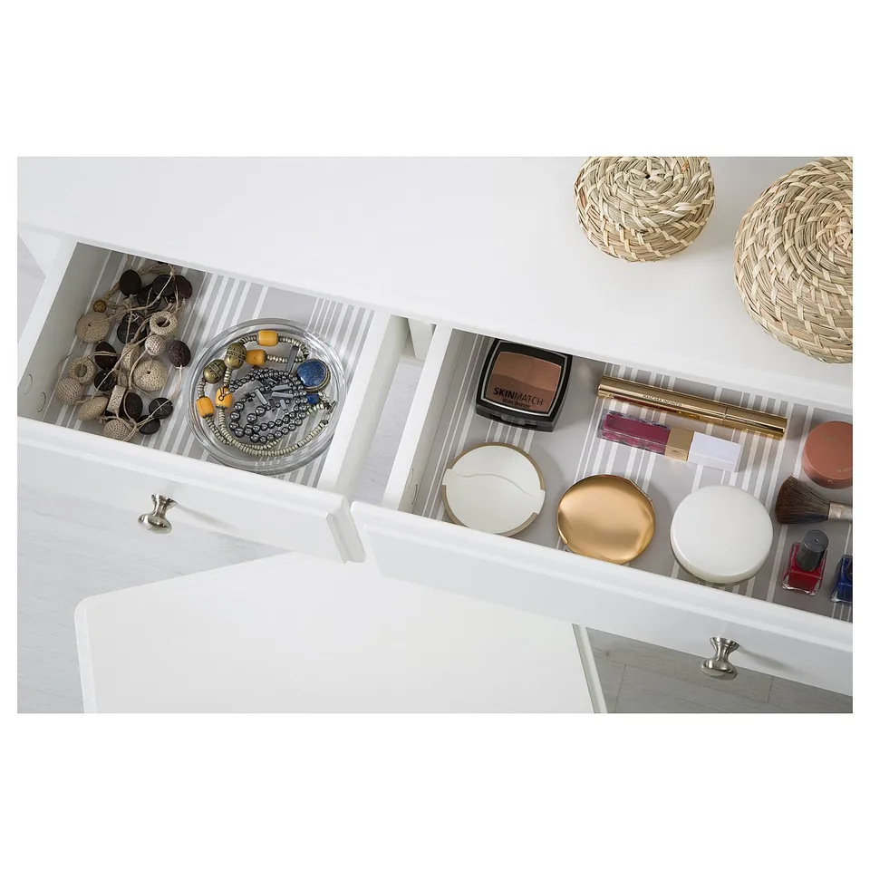 Vanity drawer with jewellery, makeup, brushes, and containers neatly organised.