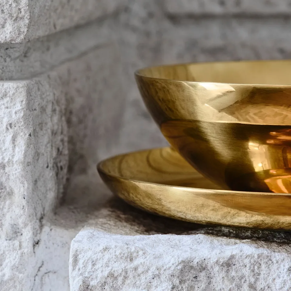 Gold dishes nested, reflecting light.