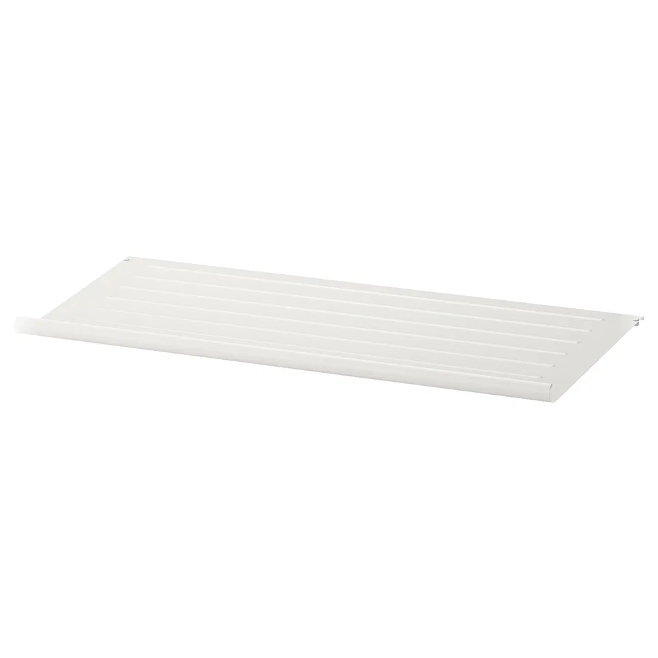 A white KOMPLEMENT shelf, rectangular in shape, with a slanted design and contoured edges, made of powder-coated steel.