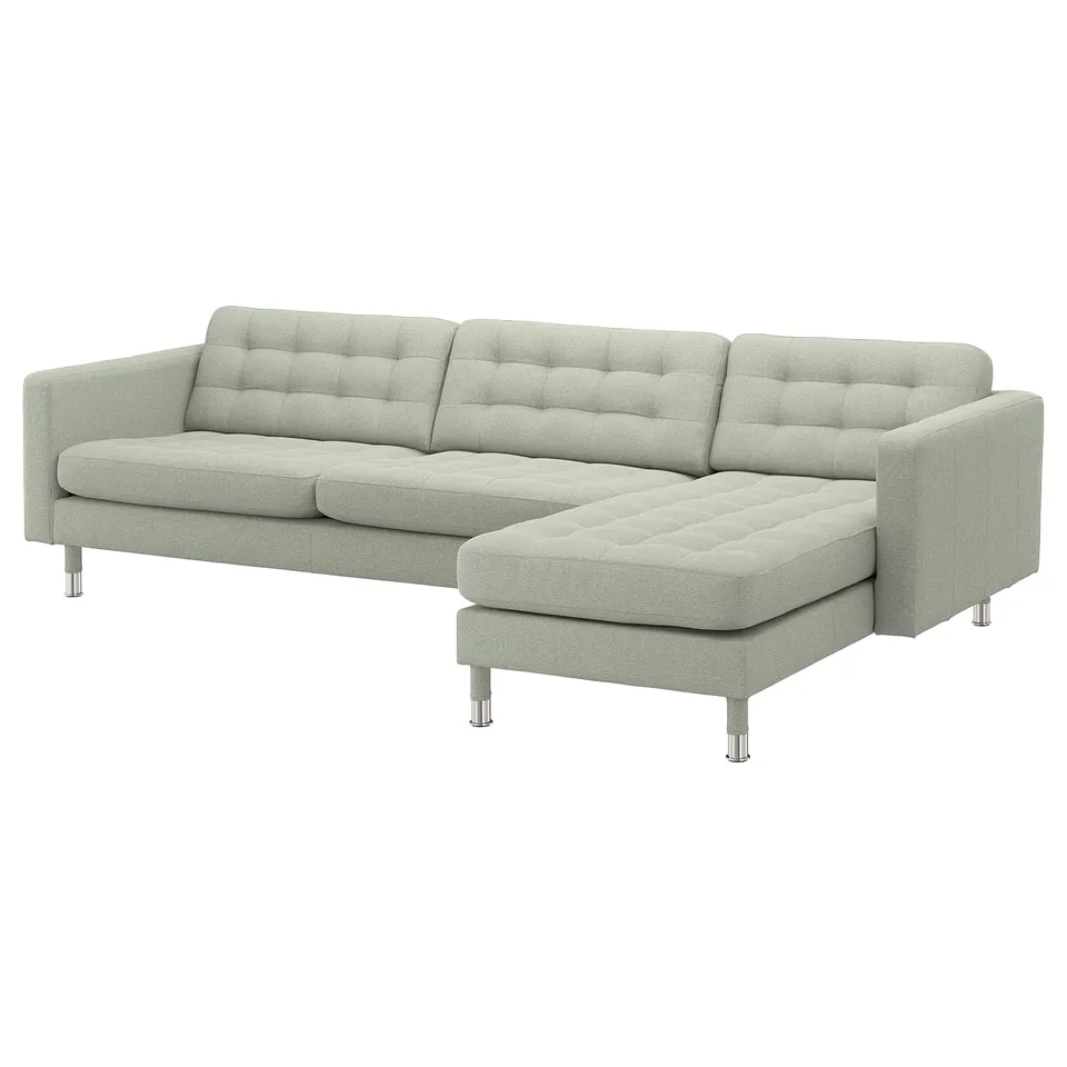 Modern light green l-shaped sofa with tufted back and seat cushions. Chrome-finished legs. Neat and stylish design.