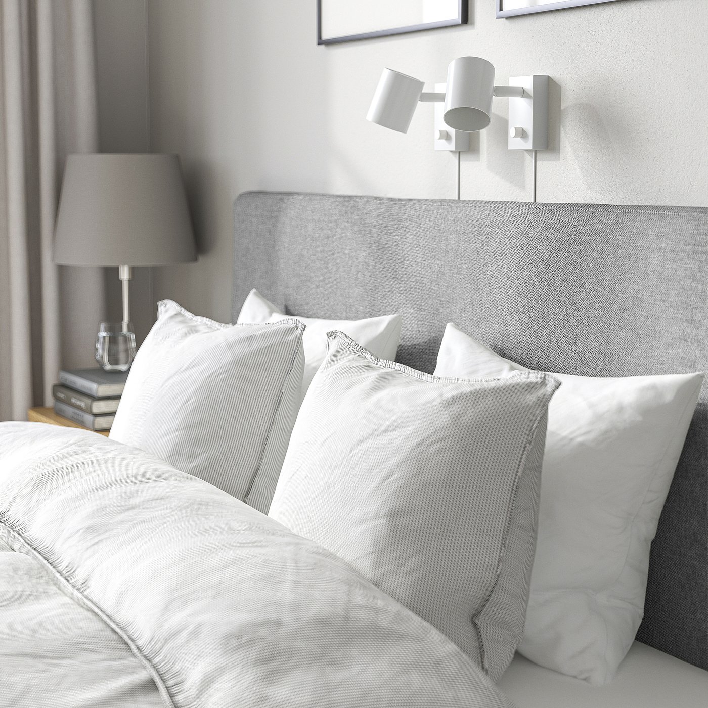 A cosy modern bed with a grey headboard, white pillows, and lamps on both sides, evoking a relaxing atmosphere.