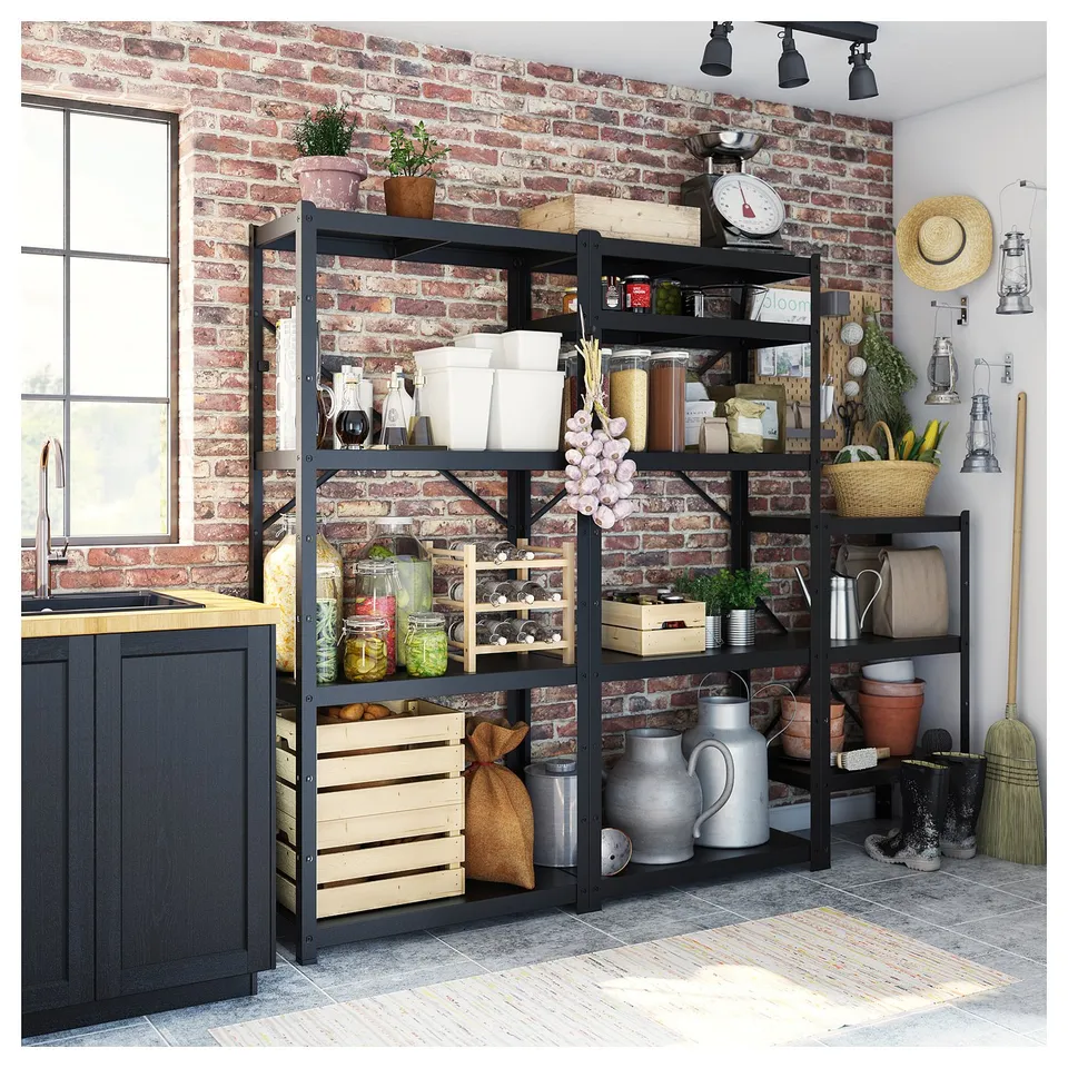 Black metallic storage shelves against a brick wall, holding various kitchen items like jars, containers, and plants.