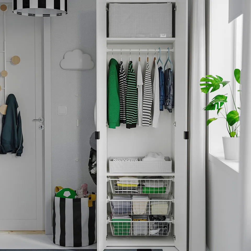 Organised closet with hanging clothes, folded items, and storage bins.